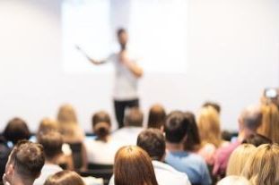 man speaks to seated audience